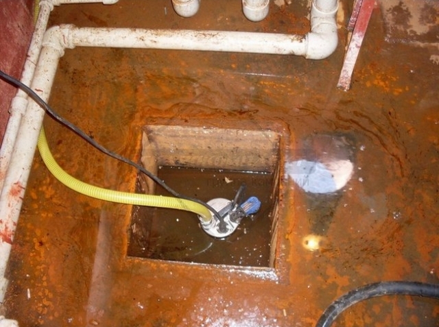 Дренажный насос выкачивает воду из приямка в подвальном помещении
